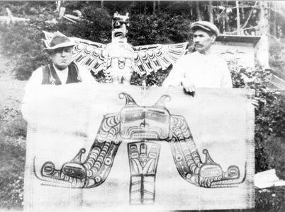 Charlie James (left) and Mungo Martin (right) holding a cedar bark mat, ca. 1930