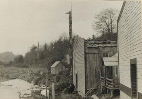 New totem pole; Side view in front of waterfront house, Kalagwees (Qaloǧʷis), 1912