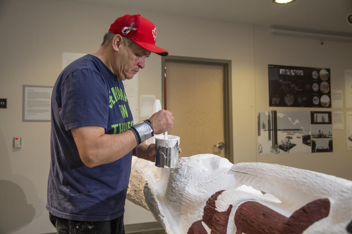 Lead carver Tom Hunt Jr. restores the Smith Family Totem Pole